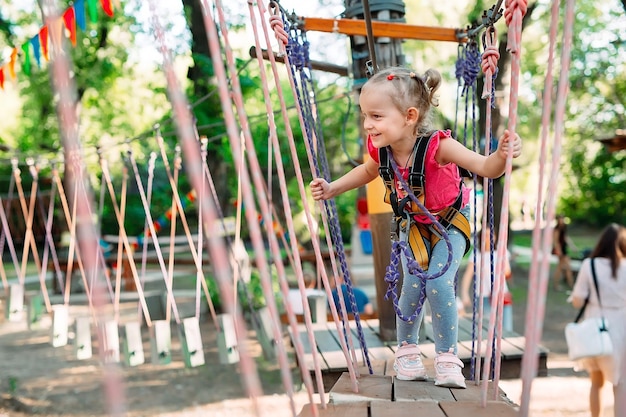 Rope Park. The kid passes the obstacle in the rope Park.