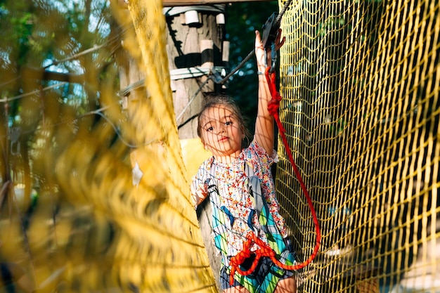 Rope Park. The kid passes the obstacle in the rope Park.