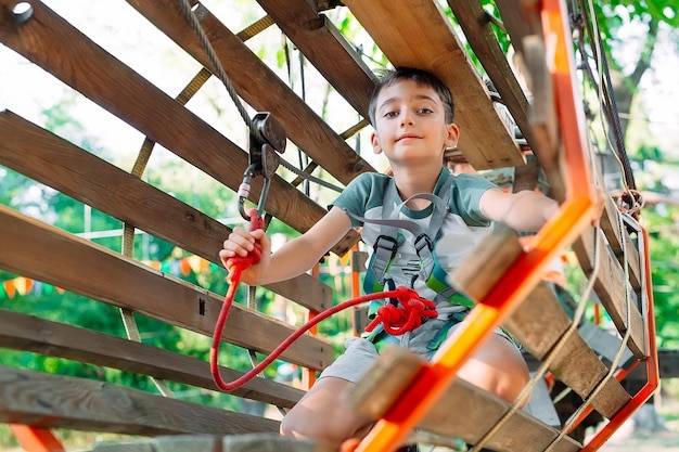 Parco della corda. il ragazzo supera l'ostacolo nel parco avventura.