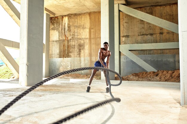 Foto rope workout sport man doen strijd touwen oefening buiten zwarte mannelijke atleet oefenen doen