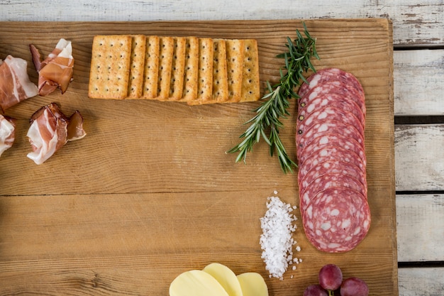 Roquefort kaas, koekjes en ham met diverse ingrediënten op snijplank