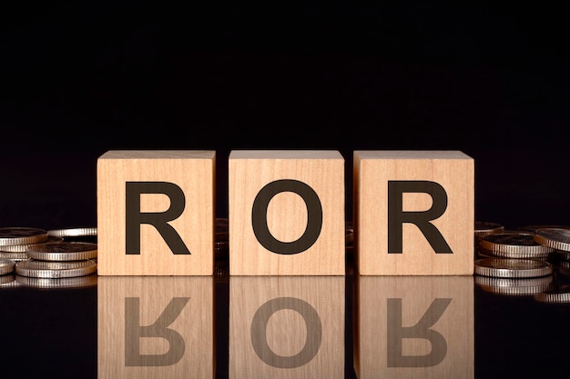 사진 ror은 동전 검정 배경 비즈니스 개념이 있는 나무 큐브에 있는 텍스트의 약자입니다.
