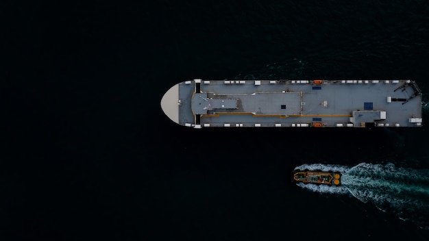 Foto roro-schip en sleepboot zeilen in de donkere zee luchtbeeld van boven transport internationaal concept