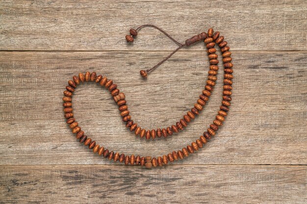 Rosary beads on wooden background.