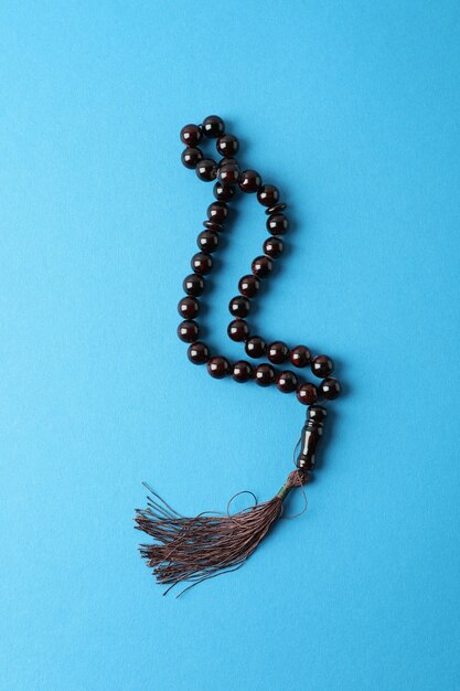 Rosary or prayer beads on blue surface