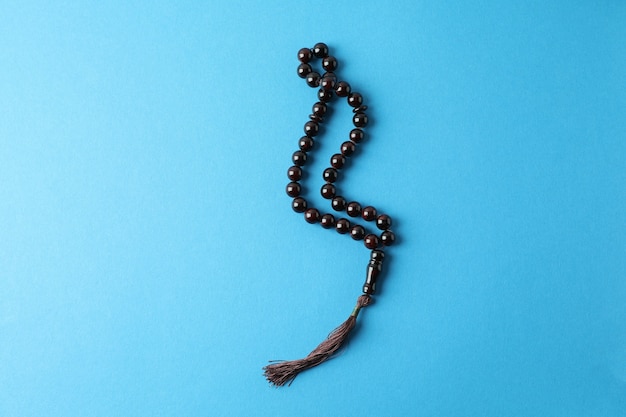 Rosary or prayer beads on blue surface