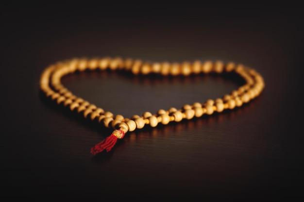 Rosary of sandalwood on a wooden table laid out in the form of a tree