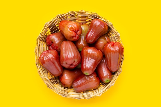 Rose apple in bamboo basket on yellow background