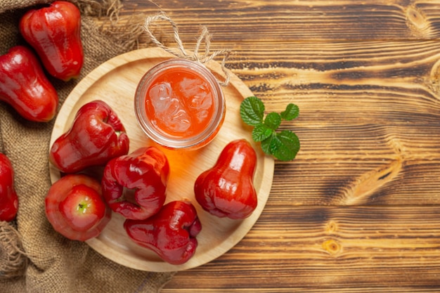 Rose apple juice on dark wooden surface