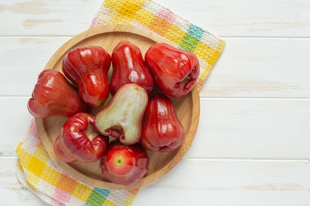 Photo rose apple on white wooden surface