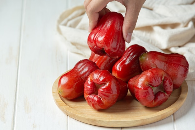 Rose apple on white wooden surface