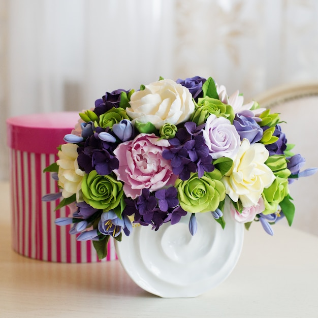 Rose flower bouquet and gift box on wooden table