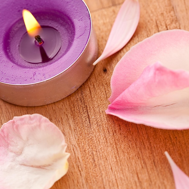 Rose leafs with candel on wooden background