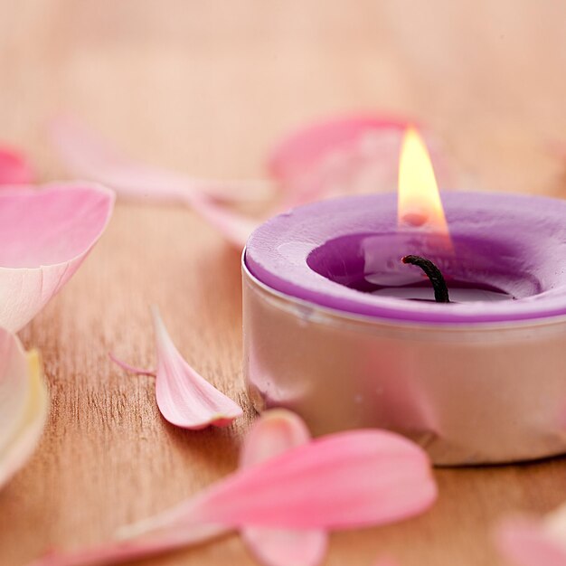 Rose leafs with candel on wooden background