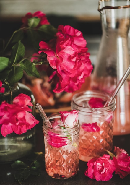 Rose limonade met ijs en bloemblaadjes over aanrecht close-up