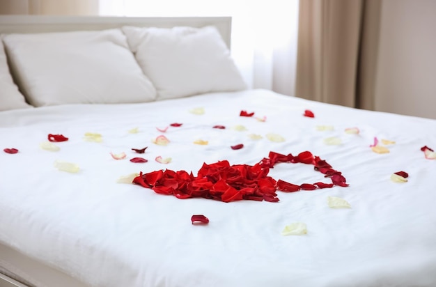 Rose petals on bed in hotel room