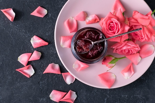 Rose petals jam on a black surface