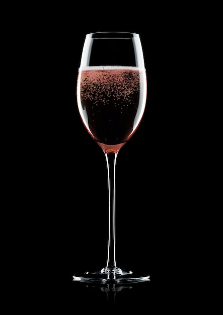 Rose pink champagne glass with bubbles on black