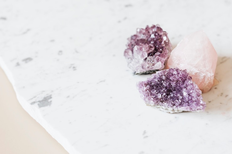 Photo rose quartz and amethyst healing crystals on a marble countertop