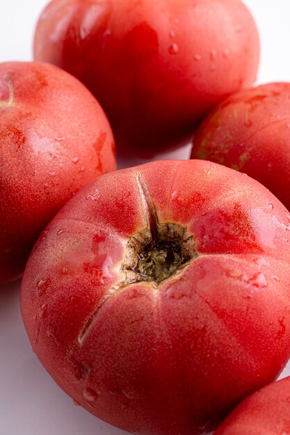 Rose tomaten close-up op witte tafel. Herfst- of zomeroogst. vers biologisch voedsel uit de tuin