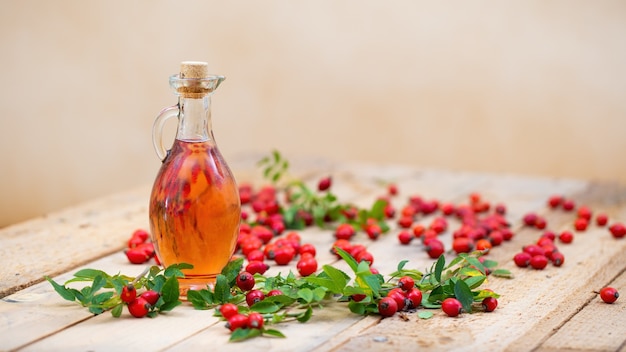 Rosehip oil in bottle laid on wooden palette