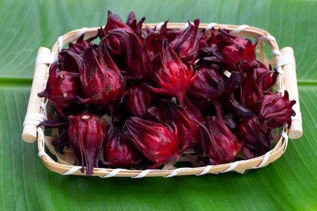 Fiore di roselle in cesto di bambù su foglia di banana