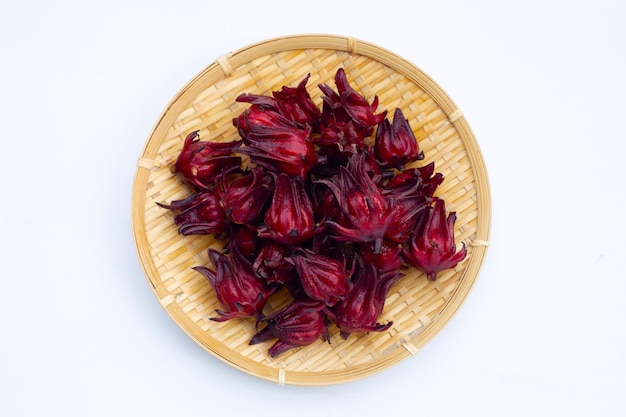 Roselle flower in round bamboo basket on white background.