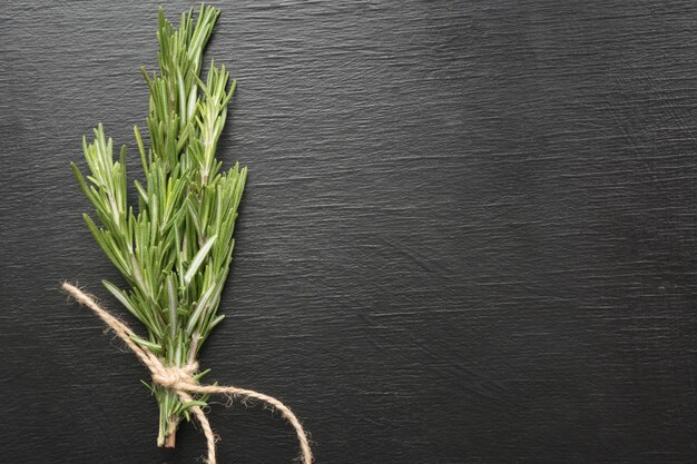 Rosemary bound on a black wooden board.