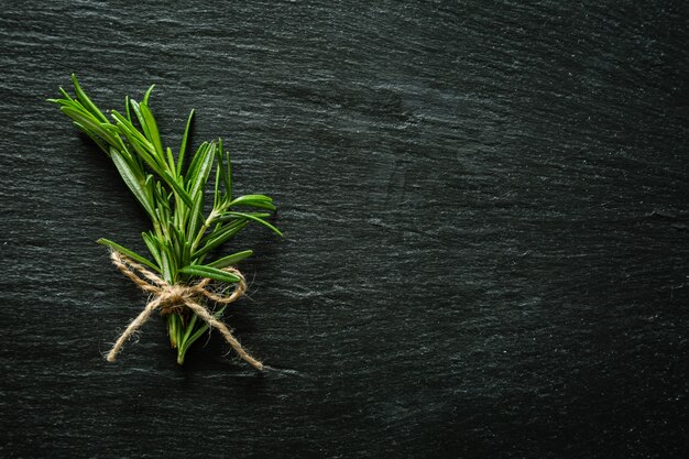 Rosemary bunch on rustic wood table, copy space