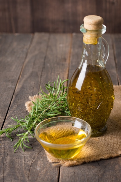 Rosemary oil on wooden background