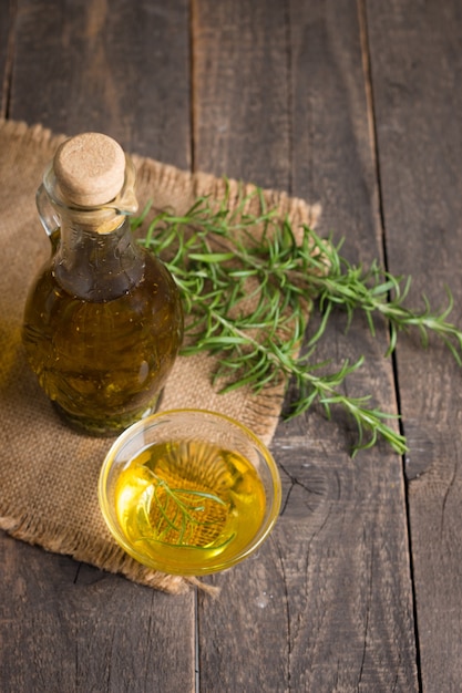 Rosemary oil on wooden background