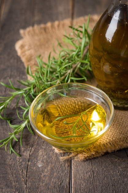 Rosemary oil on wooden background