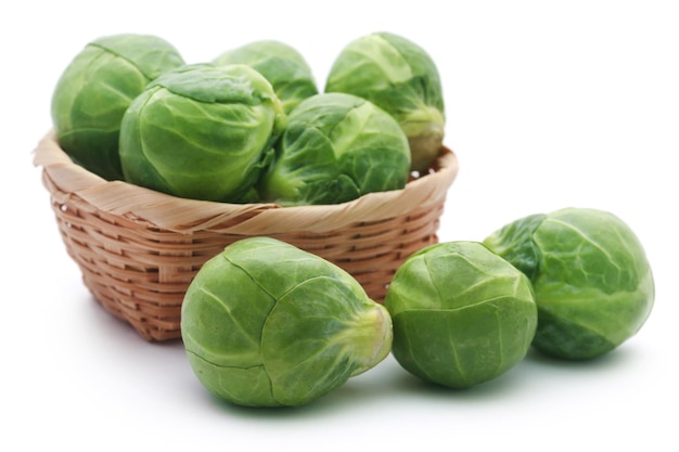 Rosenkohl or Brussels sprouts in a basket isolated over white background