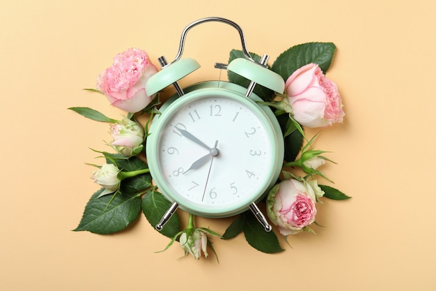 Photo roses and alarm clock in beige