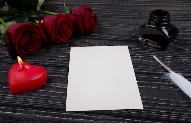 Roses, a candle, a card, a feather and an inkpot