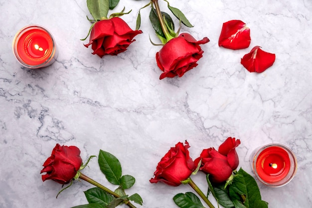 Roses and candles on a white marble surface Cropped view Valentines Day