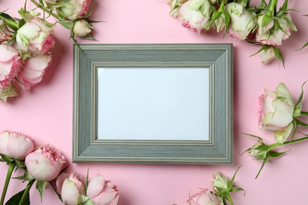 Roses and empty frame on pink