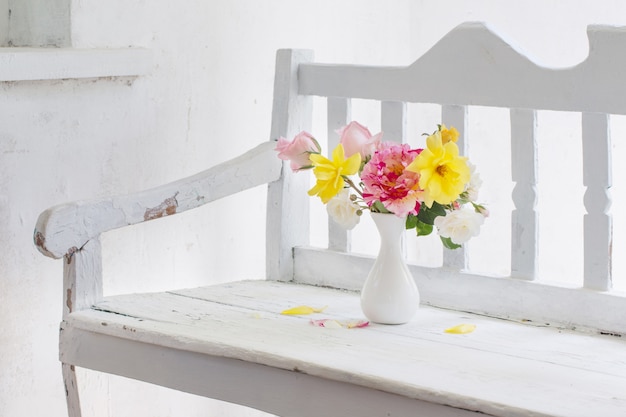 Roses oin vase on white wooden bench