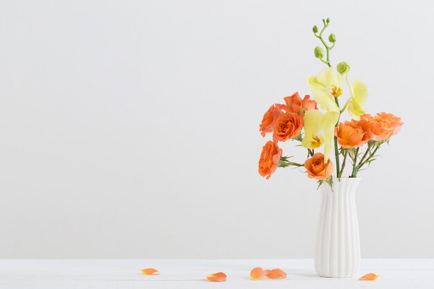 Roses and orchids in white vase