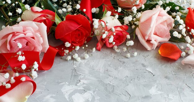 Roses and small white flowers close up on a grey background