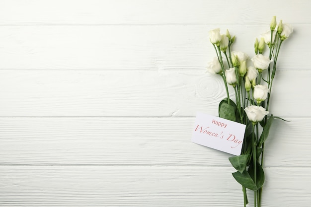 Розы и текст счастливый женский день на белом фоне деревянные