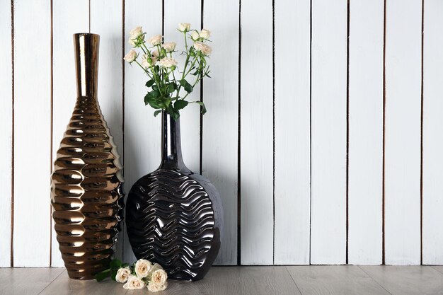 Roses in vase on wooden background