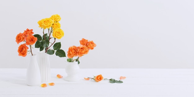 Roses in white vase on white