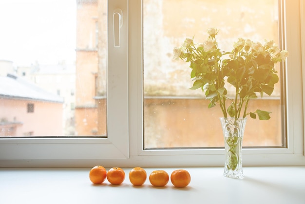 Roses with tangerines on window sill Healthy and beautiful lifestyle Cosy home ideas