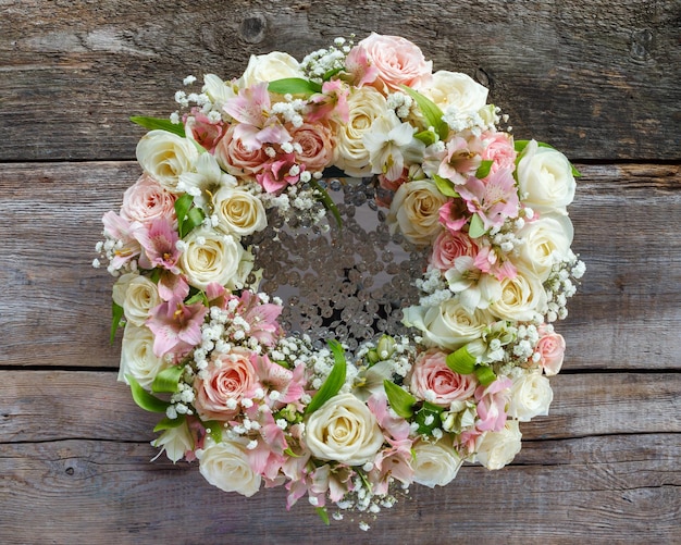 Roses wreath on wooden background