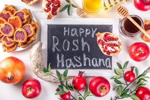 Foto rosh hashana joodse vakantie achtergrond met rode appels honing granaatappel sjofar en beker joodse nieuwjaarsvakantie met traditionele symbolen gelukkig rosh hashana wenskaart