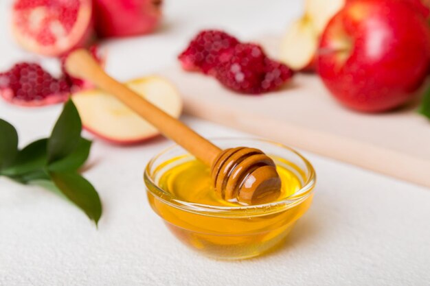 Rosh hashanah jewish holiday concept honey apple and pomegranate with cutting board close up