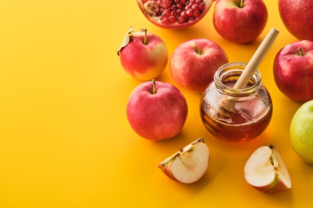 Rosh hashanah jewish New Year holiday concept. Apples, honey, pomegranate.