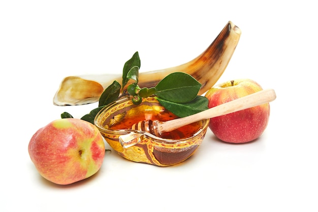 Rosh Hashanah 유대인 새해 휴일 개념 꿀 사과와 쇼파가 있는 사과 모양의 그릇은 흰색 배경에 격리된 휴일의 전통적인 상징입니다.