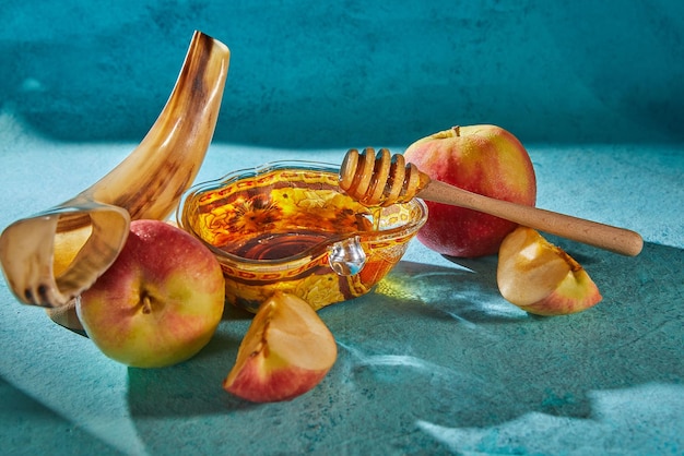 Rosh hashanah jewish new year holiday concept Appleshaped bowl with honey apples shofar are traditional symbols of the holiday